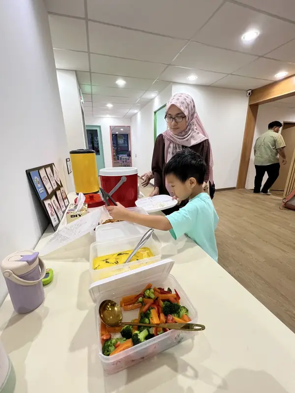 A learner practising independence during a meal routine